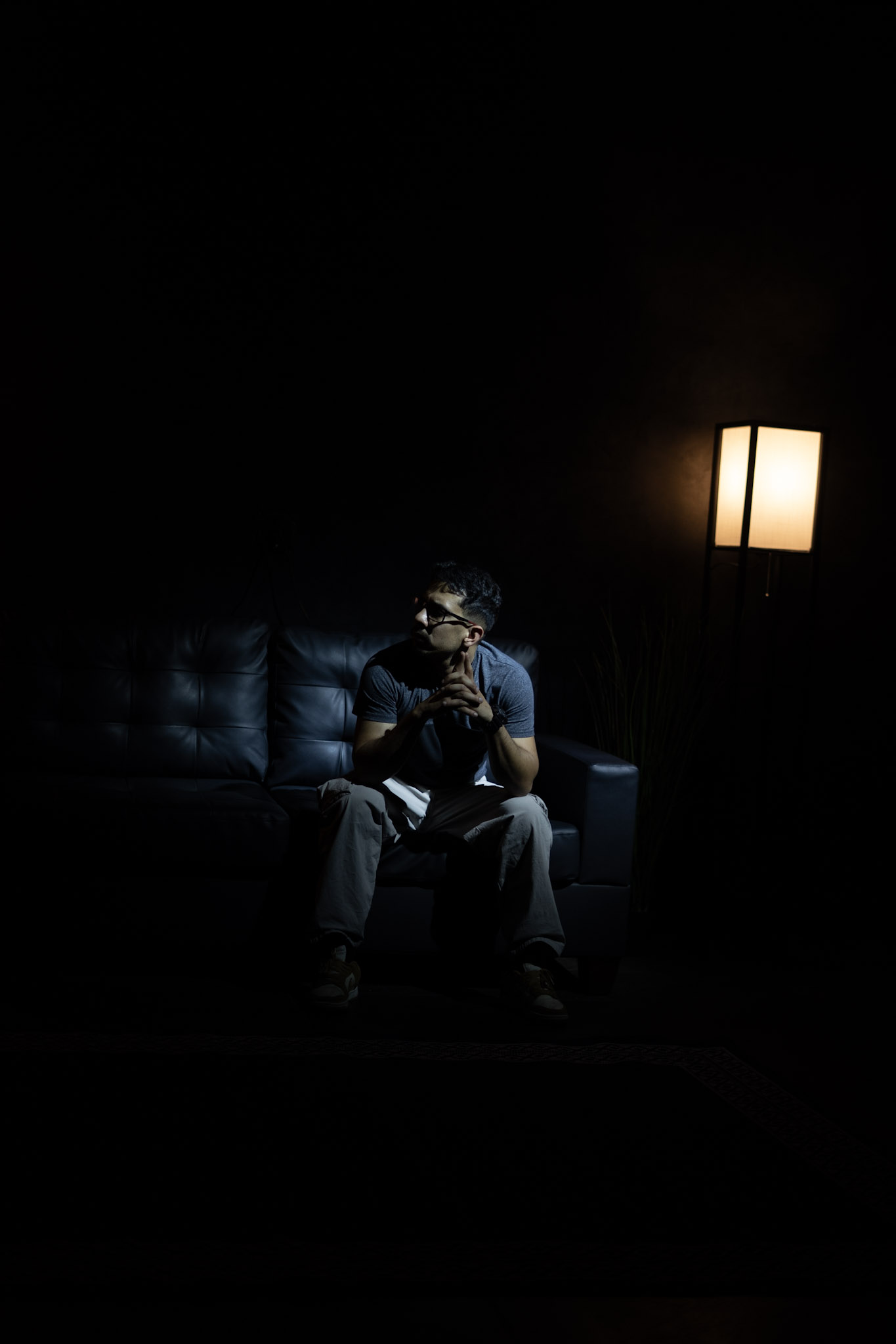 Manuel Quero seated in a dark lounge lit by a single lamp