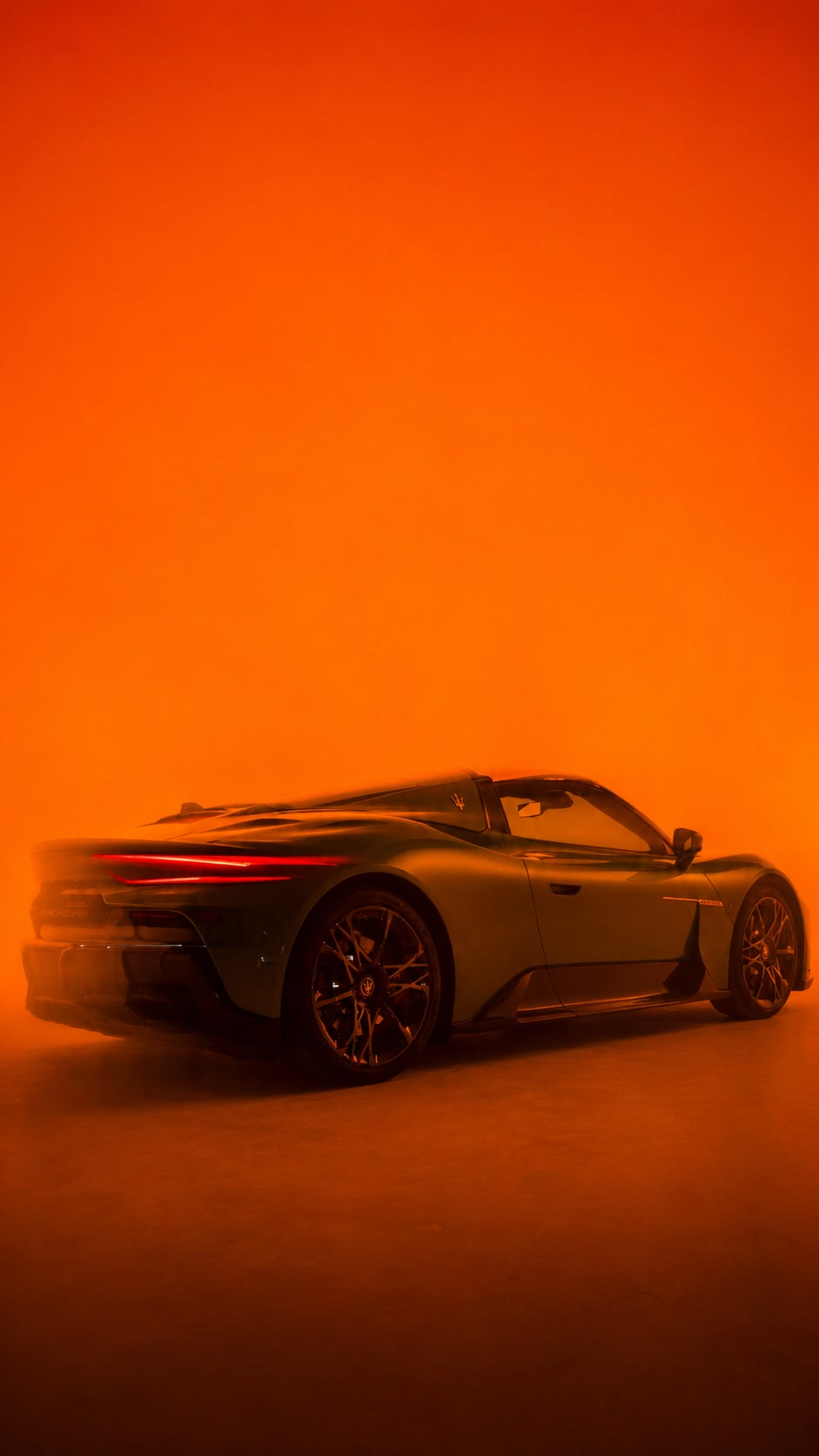 Luxury sports car in a studio filled with orange haze, cinematic automotive photography
