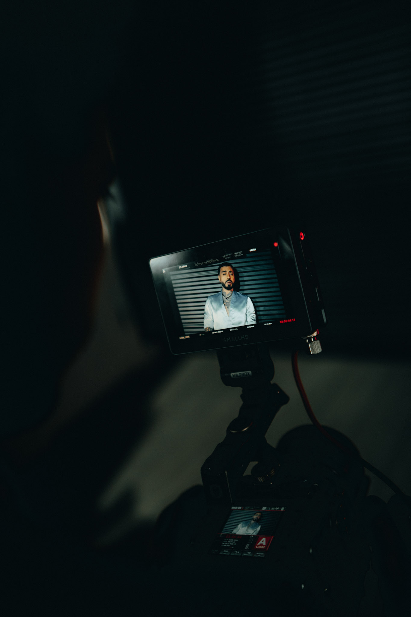 Field monitor showing an artist in a silver jacket during a music video production